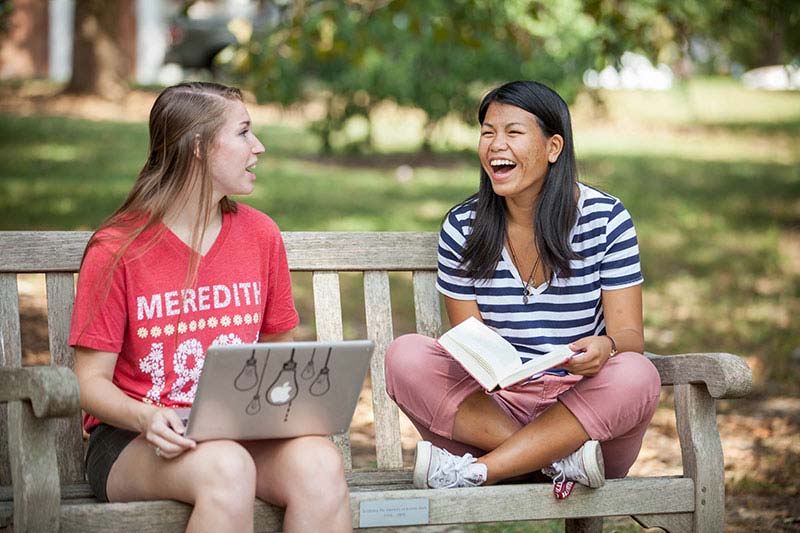 Two students smiling and laughing.